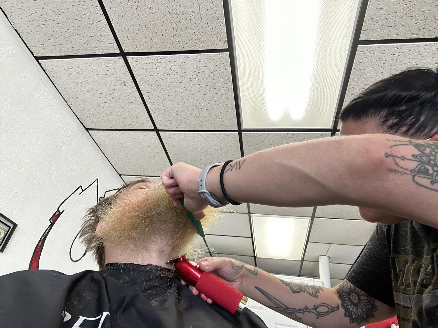 A barber at Levels Up giving a clean clipper lineup